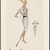 Double-breasted check dress with short sleeves and contrast buttons and belt; bias cut trim around shoulders closes at bodice with button tab giving dress a capelet effect
