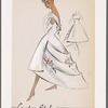 Sleeveless evening gown with dipped hemline and wide tiers at back; bateau neckline forms deep V at back