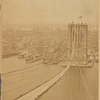 View of Manhattan waterfront and Brooklyn Bridge under construction; temporary footbridge 