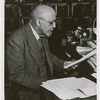 W.E.B. Du Bois reading papers in his office