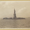 Statue of Liberty from the harbor with view of Ellis Island