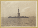 Statue of Liberty from the harbor with view of Ellis Island