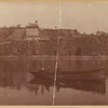 Two men in small boat; view of Fort Wendel amusement park