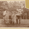 Poe Cottage on original site, man wearing boater hat at gate