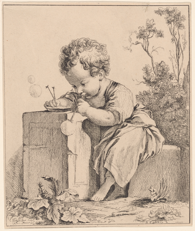 A child seated, blowing bubbles