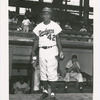 Brooklyn Dodgers infielder Jackie Robinson outside the team's dugout at Ebbets Field, Brooklyn, New York, with centerfielder Duke Snider (at left in dugout) and pitcher Preacher Roe (sitting at right in dugout), circa 1950