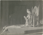 Scene from the stage production The Miracle (woman laying down, queen with baby on throne)