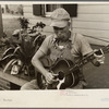 Westmoreland homesteader playing a mouth organ and a guitar, Pennsylvania