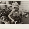 Westmoreland homesteader playing a mouth organ and a guitar, Pennsylvania