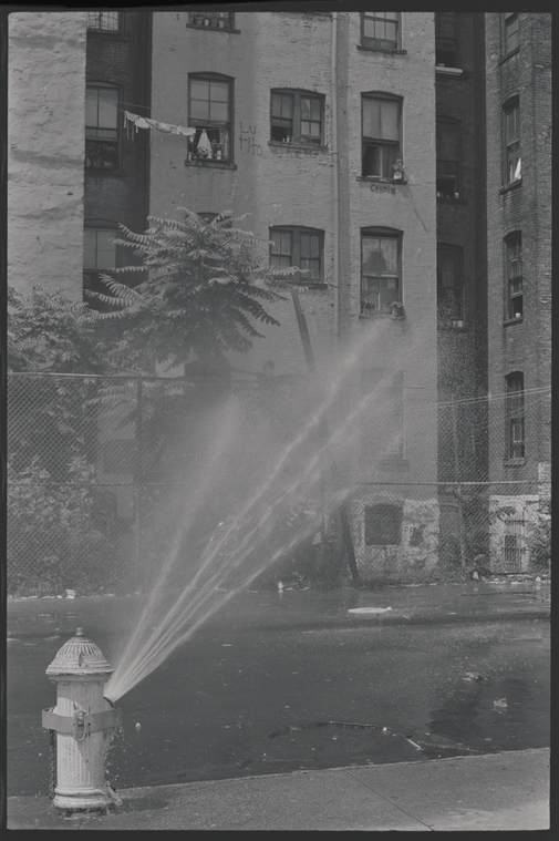 Street scene with open fire hydrant.