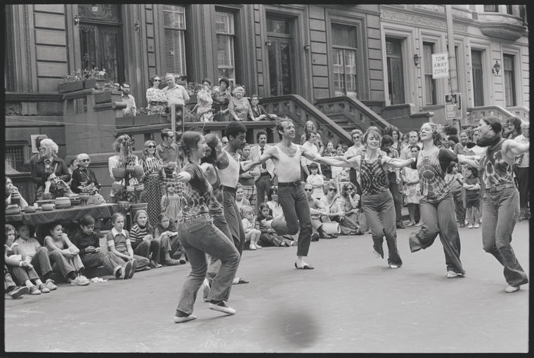 dancers in a circle with bystanders watching