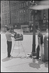 Artist painting on street corner. New York, NY