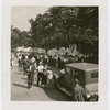 View of marchers following a sign depicting a Soviet worker standing on the top of the Earth, at  the Scottsboro protest parade, in Harlem, New York