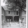 Group (5, with local boy standing on left) outside dilapidated house during performance of The Gift