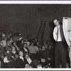 Ken Dewey and student holds up map, with audience visible, as part of "Capture the Flag" happening at Jyväskylä, Finland