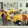 Ken Dewey (coming around) and others in front of yellow pickup truck during staging of Cincinnati Journey (happening sponsored by Art Association of Cincinnati)