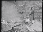 Man warming himself by a fire in a derelict lot