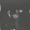 Edward Albee holding a program from the 1965 benefit to rebuild Caffe Cino after a fire, as Joe Cino (left) looks on