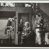 Woman with hat on knee talking to three men
