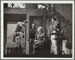 Woman with hat on knee talking to three men