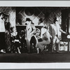Three men standing, two women sitting