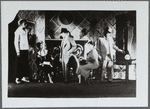 Three men standing, two women sitting