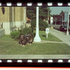 Small lawn in front of building with a wheel cannon and lamp post