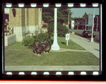 Small lawn in front of building with a wheel cannon and lamp post