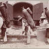 Three men with large water jars on their backs