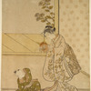 A woman holding up a demon mask to amuse her small son who sits upon the floor before her