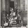 Family with packages in front of residential building (England?)