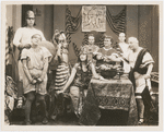 Raymond McKee (glasses), Juanita Fletcher, William Wadsworth (at table in dark toga) and unidentified others in the motion picture short Friends, Romans and Leo