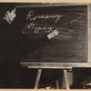 Roma man writing “Romany” and “Gypsy” on a blackboard