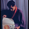 Hugh Laing in Japanese costume with chrysanthemum book