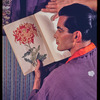 Hugh Laing in Japanese costume with chrysanthemum book