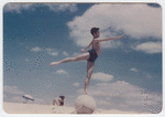 Jerome Robbins at the beach balancing in arabesque on ball
