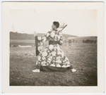 Jerome Robbins dancing outdoors in robe with fan