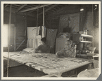 Grandmother from Oklahoma with grandson, working on quilt. California, Kern County