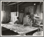 Grandmother from Oklahoma with grandson, working on quilt. California, Kern County