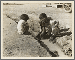 Mexican children playing in ditch which runs through company cotton camp near Corcoran, California