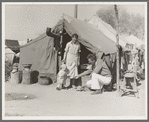 Tom Collins, manager of Kern migrant camp, with drought refugee family. California