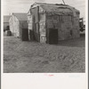 Migratory field worker's home on the edge of a pea field. The family lived here through the winter. Imperial Valley, California
