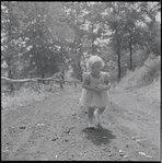 Little girl walking on dirt path