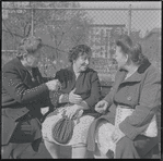 Three women conversing on bench. New York, NY