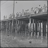 Pier with swimmers in foreground