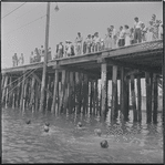Pier with swimmers in foreground