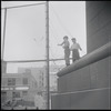 Two boys playing with a barbed wire fence. New York, NY