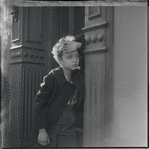Child standing in a doorway. New York, NY