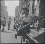 Woman standing on front stoop. New York, NY