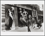 People on the street walking past a large Versace advertisement